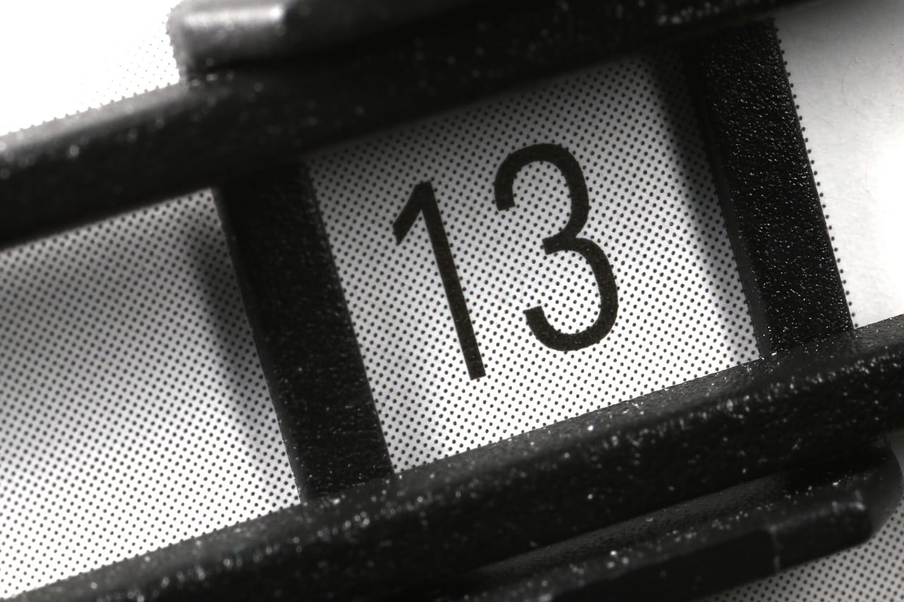 Photo en noir et blanc représentant le nombre 13 dans une sorte de cadre noir.