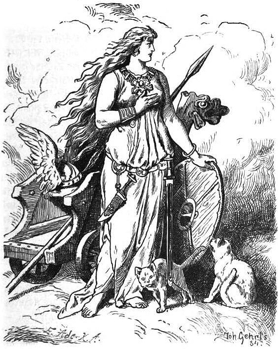 Illustration représentant une femme debout contre un char sur lequel se trouve une lance et un casque ailé. La femme a de long cheveux clairs détachés, elle porte une robe semblable à une toge et un énorme collier, ainsi qu’une dague et une épée à sa ceinture. Elle s’appuie contre un bouclier, et près d’elle se trouvent deux chats.