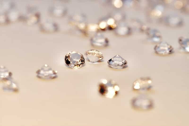 Petits diamants taillés disposés sur une surface jaunâtre